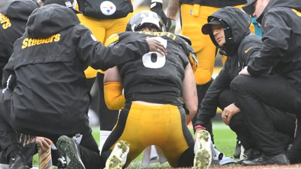 Steelers quarterback Kenny Pickett is attended to on the field after getting hit.